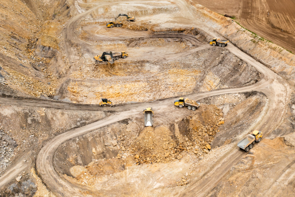 Aerial view of excavators digging ground. Opencast mining quarry.